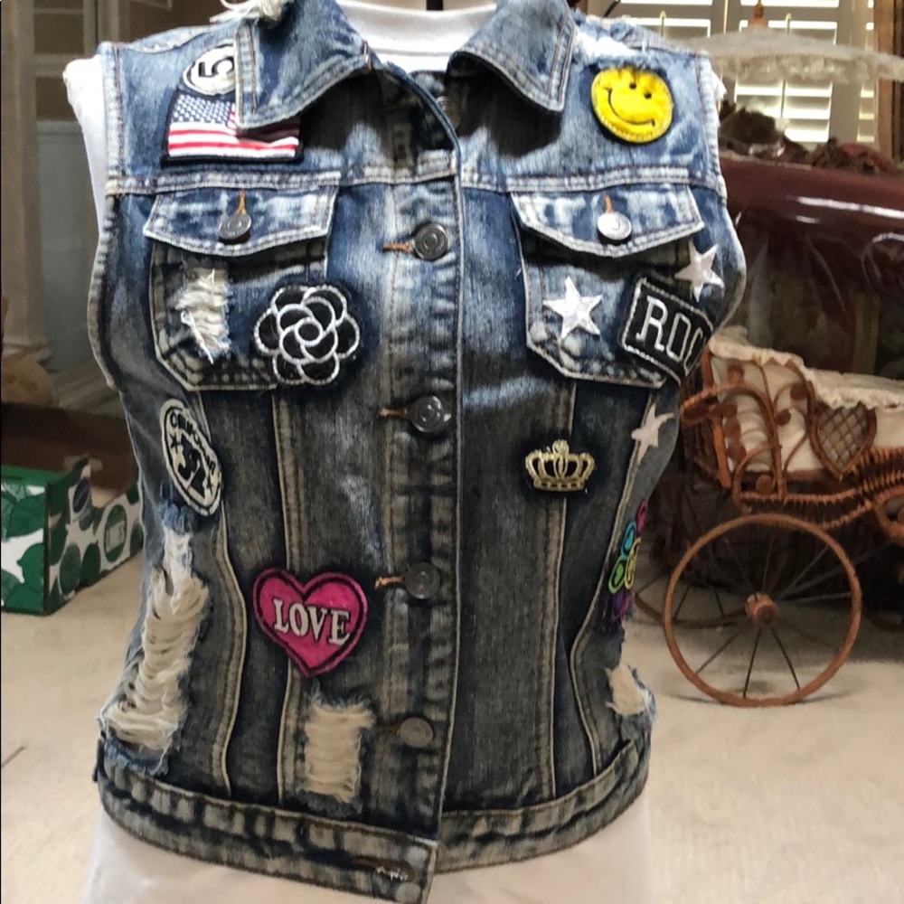 Jean moto vest with various patches distressed.